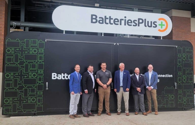 News 8 Six men in business attire stand in front of a Batteries Plus store entrance.